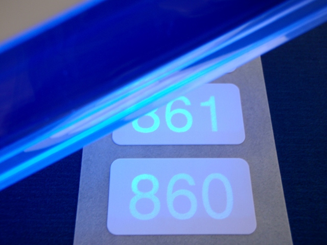 Sichtbar machen des Aufdrucks mit speziellem UV-Licht Eine spezielle UV-Lampe macht die Lumineszenz-Sicherheitsnummerierung sichtbar