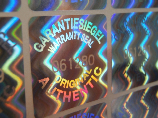 Hologrammsiegel mit manipulationssicherer  lasergravierter Nummerierung Manipulationssicheres Hologrammetikett mit fortlaufender Laser-Nummerierung im Format 20x20 mm