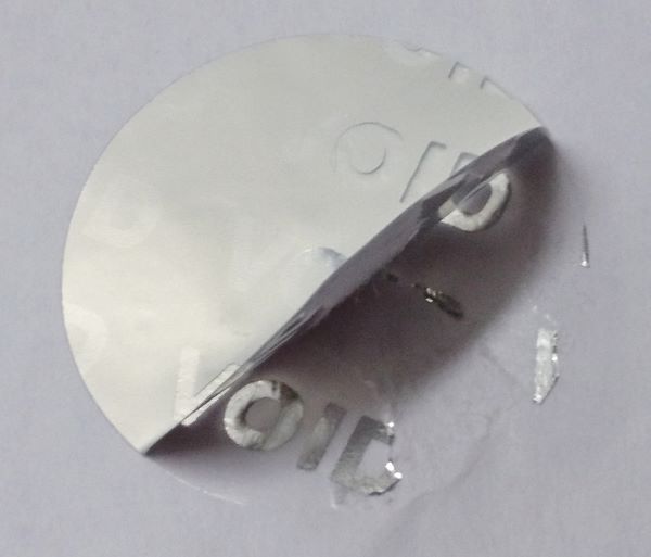 rundes Siegel aus silberner Sicherheitsfolie mit Void-Effekt bei unerlaubtem Ablösen